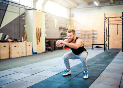 Man på gym gör knäböj
