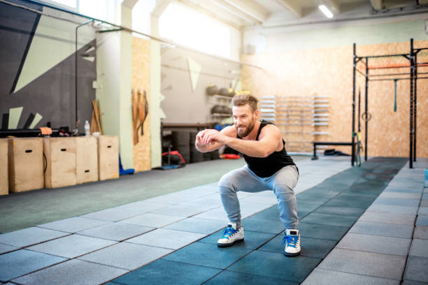 Man på gym gör knäböj
